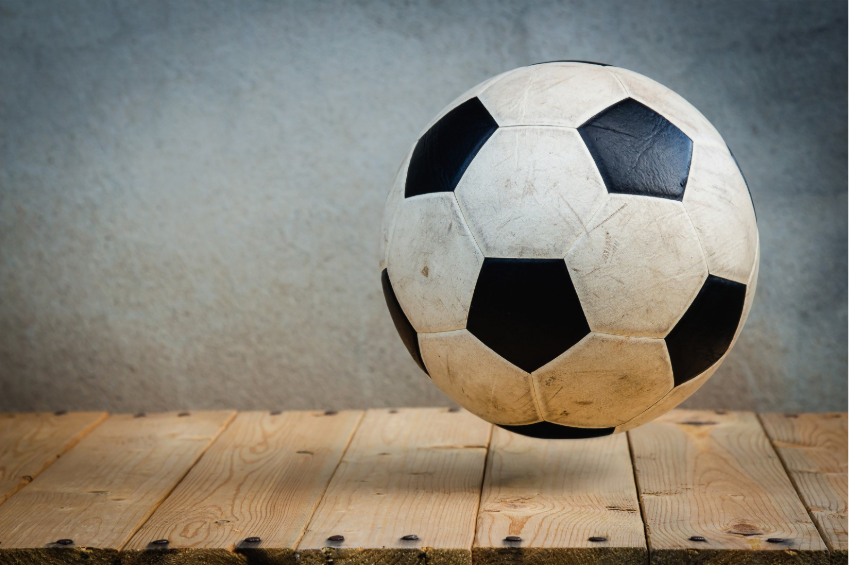Bola de futebol sobre superfície de madeira - ilustração de jogos e movimento