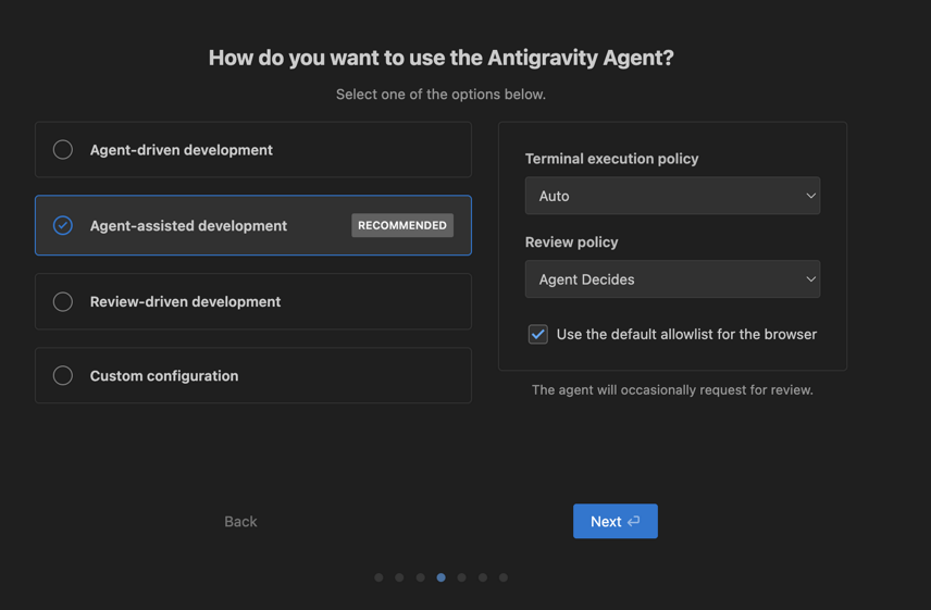 Captura de tela de uma ambiente de instalação, com o fundo escuro. Centralizado no topo o título da aba "How do you want to use the Antigravity Agent" e o subtítulo "Select one of the options below". Duas caixas de seleção, a primeira com as opções únicas: Agent-driven development, Agent-assisted development, Review-driven development e Custom configuration. A outra caixa com: Terminal execution policy em auto, Review poliicy em Agent Decides e o campo "Use the default allowist for the browser" marcado. E no canto inferior direito, um botão azul com o nome Next e o ícone do "Enter" e no esquerdo um botão Back. 