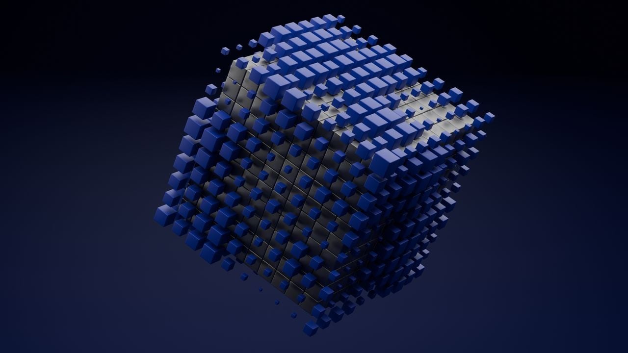 Cubo tridimensional formado por centenas de blocos azuis encaixados, com peças soltas ao redor, sobre fundo escuro. 